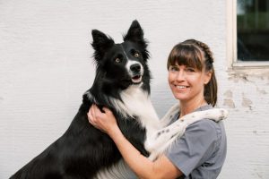 Nainen ja mustavalkoinen koira